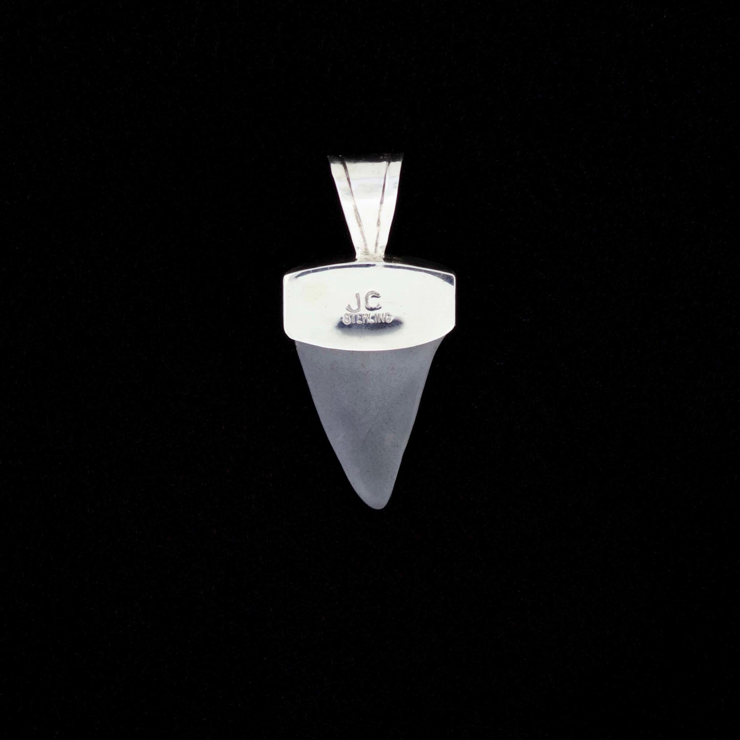 Fossil mako shark tooth pendant with blue turquoise and black onyx inlay on a black background