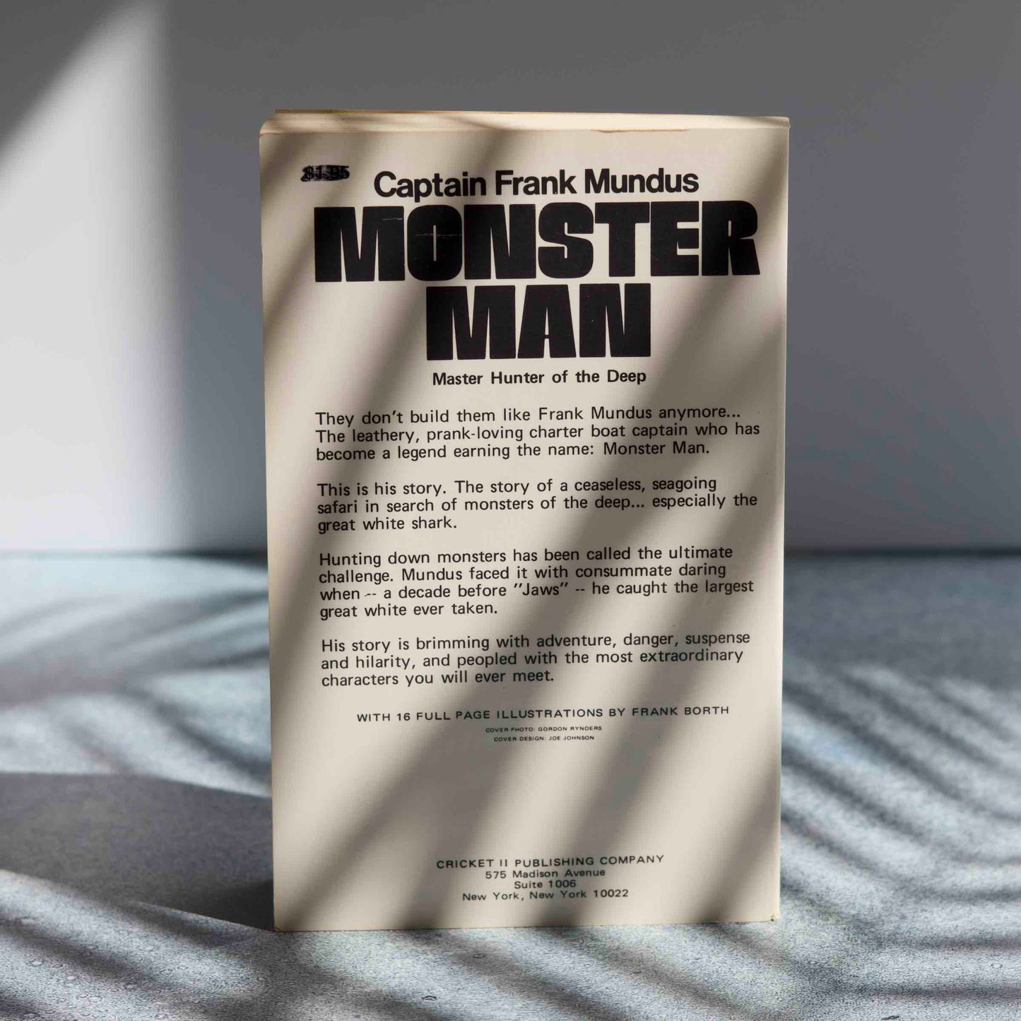 Book cover of 'Monster Man' by Captain Frank Mundus on a textured surface with light shadows.