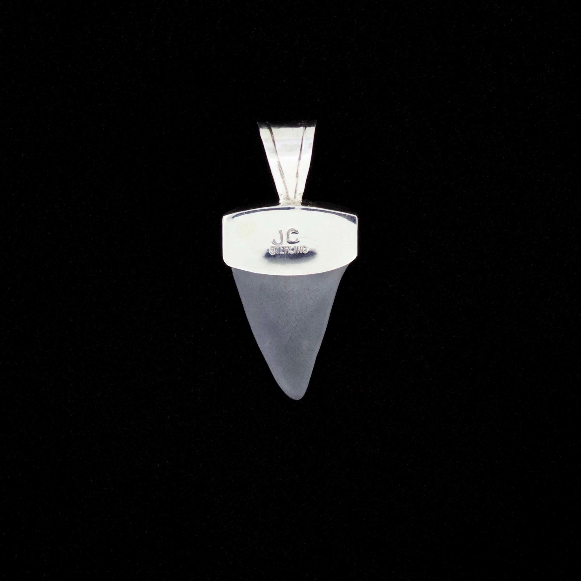 Fossil mako shark tooth pendant with blue turquoise and black onyx inlay on a black background